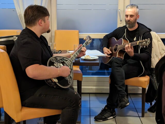 Zwei sitzende Musiker mit Bouzouki und Gitarre